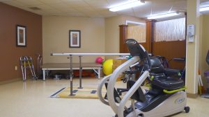 Recumbent bike and parallel bar in gym.